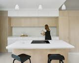 The kitchen countertops and backsplash are made from reconstituted stone—a material chosen for its durability. The pendant lamps above the island are Mini Caravaggio lights by Cecilie Manz for Fritz Hansen.&nbsp;