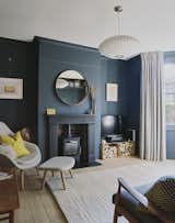 The living room is painted in Dulux Raven Plume. "I saved a bit of money by going with Dulux paint, and put the savings towards more expensive lighting," says Julia. The pendant lamp is a George Nelson Saucer Bubble Pendant Light, which was designed by George Nelson in 1947 and first produced by Herman Miller in 1952.