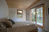 The Pella French doors in the master bedroom were salvaged from a family friend who was doing a renovation. “We can sit in bed and watch the dawn brighten through the trees,” says Diane. “Cabins are always full of recycled stuff—that’s part of the charm for me.” 