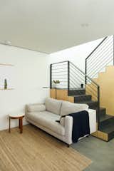 The small living space is adjacent to the stair, which conceals a number of utilities beneath it. Concrete floors give the space a refined industrial edge.&nbsp;