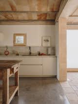 The kitchen features a marble backsplash and a precisely placed window. The floors and internal walls are also crafted from clay and concrete.