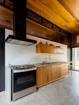 The kitchen is located behind the dining space and features a concrete counter—a reference to the industrial-style architecture.