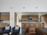 The kitchen and wet bar open out into the living area. Timber joinery adds warmth to the interior and contrasts with more industrial materials, such as the steel and concrete.