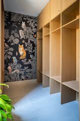 The mudroom offers plenty of built-in storage, which was essential for the family with young children. The bold panoramic wallpaper is Forêt Noire by Nathalie Lété for Moustache.