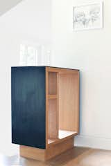 A steel-and-wood built-in “shoe drop” cabinet at the top of the stairs prevents things from piling up at the top step. As the design progressed, the home became more thoroughly “built-in,” and nearly every room has custom features, including desks, windows seats, benches, cabinets, and panelling. “This is an echo of the many craftspeople who set up shop in the nearby homes in the district 100 years ago, installing custom wood panels, handrails, built-ins, and bookshelves,” says architect Nicholas Fiore.