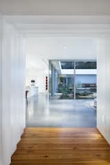“Stepping through the bridge is like going through a portal in time,” says architect Miguel Rivera. “The space opens up, and you find yourself in a brightly lit living and dining room with gray porcelain tile floors and floor-to-ceiling windows that contrast with the punched openings of the bungalow.”