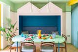 The pink bench enclosure with blue upholstered cushions is a place for the family to nestle and relax. The large mint-green table in the dining area is from Artiform’s Palladio range, and the large yellow Strom jug was designed by Nicholai Wiigh Hansen for Raawii.&nbsp;