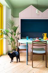 A palm sits in the corner of the dining space, near a glazed door that connects the interior to the garden. "In summertime, they can open the door and it almost feels like the dining table is outside," says architect Catrina Stewart.&nbsp;