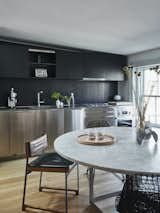 The kitchen for the main living quarters is on the top floor. The dark joinery echoes the original millwork throughout the home, while the stainless steel adds an industrial edge. 