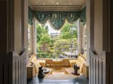 The Sundial Arcade faces south over the garden room with radial seating around a sundial. The entire window to the garden lowers into the floor with the flick of a switch, while the ruched drapes evoke the form of gathering clouds—a playful nod to London’s famously gray weather.