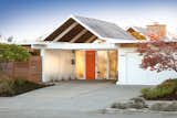 The twin gable home—which features a bright orange entrance door—is one of the most desired Eichler models of the era.