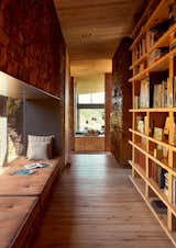 The passage that leads to the bedrooms doubles as a library, with large bookshelves and a reading window.