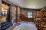 The home is entered through a firewood room that has the original stone walls. This transitional space pays tribute to the home’s mountain setting and leads into a mudroom and the main living area.