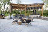 Techo-Bloc’s Blu Grande slab in Greyed Nickel creates a sophisticated backdrop for this epic outdoor kitchen and dining setting with a quartet of playful timber swings—not only is it practical, but the large size of the pavers reduces the need for joints that can collect crumbs and create unlevel surfaces for furniture. The covered kitchen and dining area is defined at the ground level with Borealis slab in Smoked Pine—an elegant wood imitation patio slab that retains the warmth of wood but features innovative Klean-Bloc technology that eliminates the need for maintenance.