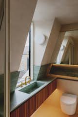 In the bathrooms, the natural materials of timber, microcement, and stone is complemented by refined details, such as opaque Flos light bulbs and polished brass fittings from Studio Ore. "This brings a sense of understated luxury into the space,