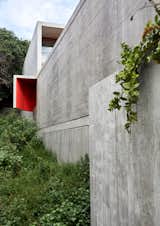 The two concrete "ears" on either side of the building help to draw the sea air into the interior while protecting the bedrooms from the wind. The vibrant red color allows them to playfully serve as punctuation points on the otherwise austere concrete facade.