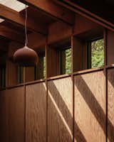 Raw terra-cotta pendant lamps, designed by Tom Housden for UK lighting brand Hand &amp; Eye, complement the natural clay finish of the handmade pamments (traditional floor tiles) used on the floor in the boot room and kitchen ,and the warmth of the Douglas fir timber panelling on the walls.&nbsp;