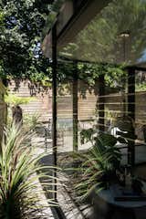 The north facing extension is double glazed with UV protection, which allows the extension to be fully wrapped in glass and immersed in the lush garden. Indoor plants help to dissolve the boundary between interior and exterior spaces.