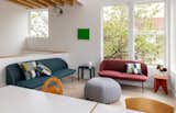 Living Room, Sofa, Light Hardwood Floor, Ottomans, End Tables, and Wall Lighting Two Experimental Townhouses Clad in Cor-Ten Steel Add Density to a Seattle Neighborhood - Photo 12 of 19 - 