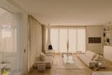 The ground floor living spaces feature large windows with sheer curtains. “In the afternoon, you get this golden hour,” says architect Alexander Saved. “The light is awesome—you almost feel like you are in California with the warm light filtering through the curtains.”