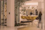 The home is built around a small central courtyard with a tree at its center, which is surrounded on the ground floor by the dining room, living room, and kitchen.