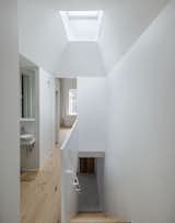 A large pyramidal skylight illuminates the common hallway, allowing natural light to reach the heart of the home.