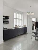 The home features a full open kitchen with a Vipp V1 Kitchen in black aluminum and stainless steel. “The Vipp products are very functional, and the kitchen has a wonderful lightness as it stands on legs,” says Thomas. “The black color of the kitchen and the stone floors match incredibly well.”