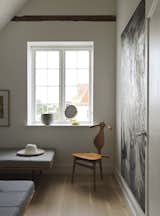 A vintage Valet Chair by Hans J. Wegner sits alongside a vintage timber and steel framed daybed in one of the bedrooms.