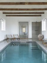 The indoor pool adjoins the main house, and features a pair of Easy Chairs by Jørgen Høj and Poul Kjærholm.