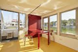 Color played an important role in the design, with red laminated plywood furniture and a vibrant yellow floor that conceals ample storage.