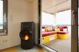 The pellet stove in the living area was a key element of the original brief, and the arrangement of the furniture in this space is a response to its placement. The interior lounge extends directly to an outside deck with a comfortable seating arrangement.  Photo 13 of 16 in How One Woman Pulled Anchor and Set Sail in a Solar-Powered Tiny Home