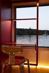 Much of the interior—including the fold-away work desk—is characterised by the bold red and yellow color palette. “Marianne is not at all afraid of bold colors and suggested we try red,” explains architect Binke Lenhardt.  Photo 8 of 16 in How One Woman Pulled Anchor and Set Sail in a Solar-Powered Tiny Home