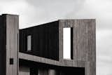 The roofs pitches align with the landscape’s different slopes, creating a sympathetic composition. The exterior is clad in burnt larch timber and features expansive glazing that embraces the views, timber floors, and natural stone details.