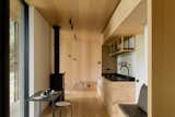 The interior walls and ceiling are made from oiled oak veneer combined with rough Rotband plaster walls. The floors are oversized oak planks—"to feel the natural timber on your bare feet," says Zemaite—and the furniture is also crafted primarily from oak, with graphic black metal details.