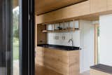 The kitchen features open upper cabinets, which are a signature of the 25x25 system and also crafted from timber leftovers created during the production process. It’s a construction approach that architect Mette Fredskild employs for the way it champions zero-waste design.