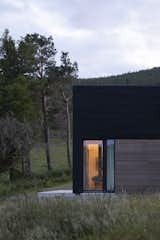 The primary cladding is black-painted larch by Russwood, with accents of unpainted timber to blend Spyon Cop into the earthen landscape.