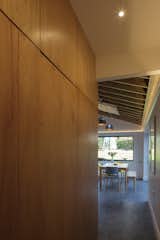 The utility room is discreetly concealed behind timber doors that blend in with the rest of the joinery and is easily accessible from the hallway and kitchen. The golden glow of this joinery picks up on the materiality of the timber rafters.