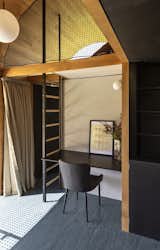 A desk is nestled below a mezzanine-style 'snug', and the <span style="font-family: Theinhardt, -apple-system, BlinkMacSystemFont, &quot;Segoe UI&quot;, Roboto, Oxygen-Sans, Ubuntu, Cantarell, &quot;Helvetica Neue&quot;, sans-serif;">joinery throughout is crafted from black, moisture-resistant MDF. “We used this as a counterpoint to the rimu lining boards, but it has texture and depth as well,” says architect William Samuels. “It was also an affordable and straightforward way for us to build our own kitchen and cabinetry.”</span><span style="font-family: Theinhardt, -apple-system, BlinkMacSystemFont, &quot;Segoe UI&quot;, Roboto, Oxygen-Sans, Ubuntu, Cantarell, &quot;Helvetica Neue&quot;, sans-serif;"> </span>