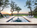 The textured stone slabs around this resort-style pool are simple yet elegant. The Travertina Raw 30 x 30 slabs are laid on an angle to create a dynamic play of lines and finished with a cap around the pool in complementary Ivory. Set against an expanse of lush lawn dotted with mature trees, it’s the definition of understated luxury.  Photo 1 of 760 in Taos by stephen mullens from These 10 Trends Will Define Outdoor Design in 2023