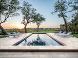 The textured stone slabs around this resort-style pool are simple yet elegant. The Travertina Raw 30 x 30 slabs are laid on an angle to create a dynamic play of lines and finished with a cap around the pool in complementary Ivory. Set against an expanse of lush lawn dotted with mature trees, it’s the definition of understated luxury.