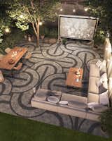 This glitzy patio that doubles as the stage for an outdoor cinema, with small stones in contrasting colors laid down in a sophisticated Art-Deco-inspired pattern. The bold pattern has been crafted using Techo-Bloc’s Squadra paver in Shale Grey and Onyx Black. The small 3x3 square cobblestones have an aged finish and are ideal for creating mosaics at ground level.