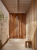 An open-air shower located off the timber-clad walkway offers another way for the homeowners and their guests to connect with nature, and an easy way to rinse off after swimming.&nbsp;