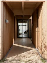 The entrance to the home is through a timber-clad passageway that leads to a guest annexe, a utility shed, and the main house. Whilst traditional Danish summer houses are often clad in dark timber, this contemporary interpretation of the typology inverts expectation by using a light Canadian cedar cladding—most expressively in this walkway.