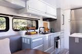 The sleek aluminum kitchen features plenty of storage—much of it inspired by the storage aboard luxury yachts, which locks away to prevent movement while traveling.  Photo 7 of 14 in This $300K Off-Grid Travel Trailer Even Comes With a Walk-In Closet