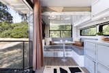 A bunk bed rises to ceiling level above a lounge and dining area when not in use, making the most of the small footprint.  Photo 4 of 14 in This $300K Off-Grid Travel Trailer Even Comes With a Walk-In Closet