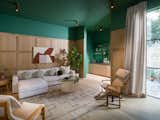 The oak flooring creates a clean backdrop for the rest of the interior scheme, which celebrates layered textures, vibrant splashes of color, and sumptuous textiles. In the sitting room, emerald green walls and oak paneling set the scene for luxury living.
