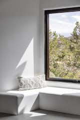 A built-in window seat wraps around a corner offering the perfect spot to contemplate the piñon pine-dotted mountains. These ledges are also an opportunity to display Moore’s collection of textiles.
