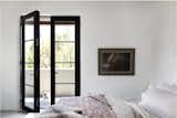 The guest bedroom features access to a balcony through the Ultimate Inswing French Door by Marvin, which echoes the lines and sleekness of the windows used throughout.  Photo 7 of 14 in A Dilapidated Pueblo-Style House in Santa Fe Gets a Modern Makeover