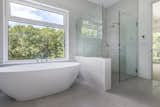 An enormous freestanding bath in the spa-like master en-suite shares the same treetop views as the bedroom.