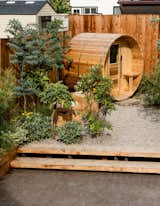 Orca Living frequently integrates wellness features into residential gardens, such as this small timber sauna. The materiality of the sauna complements the timber fence and stairs.